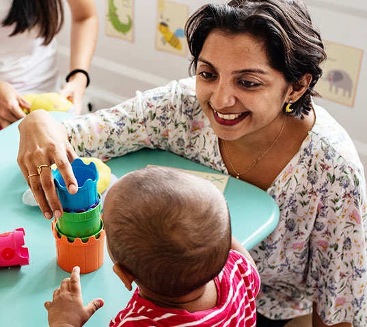 teacher and child playing with cups