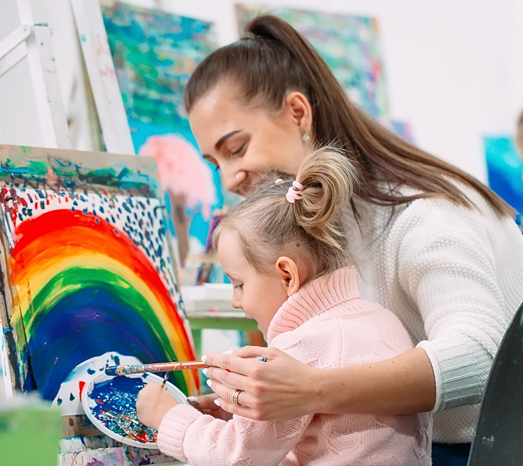 teacher helping child paint