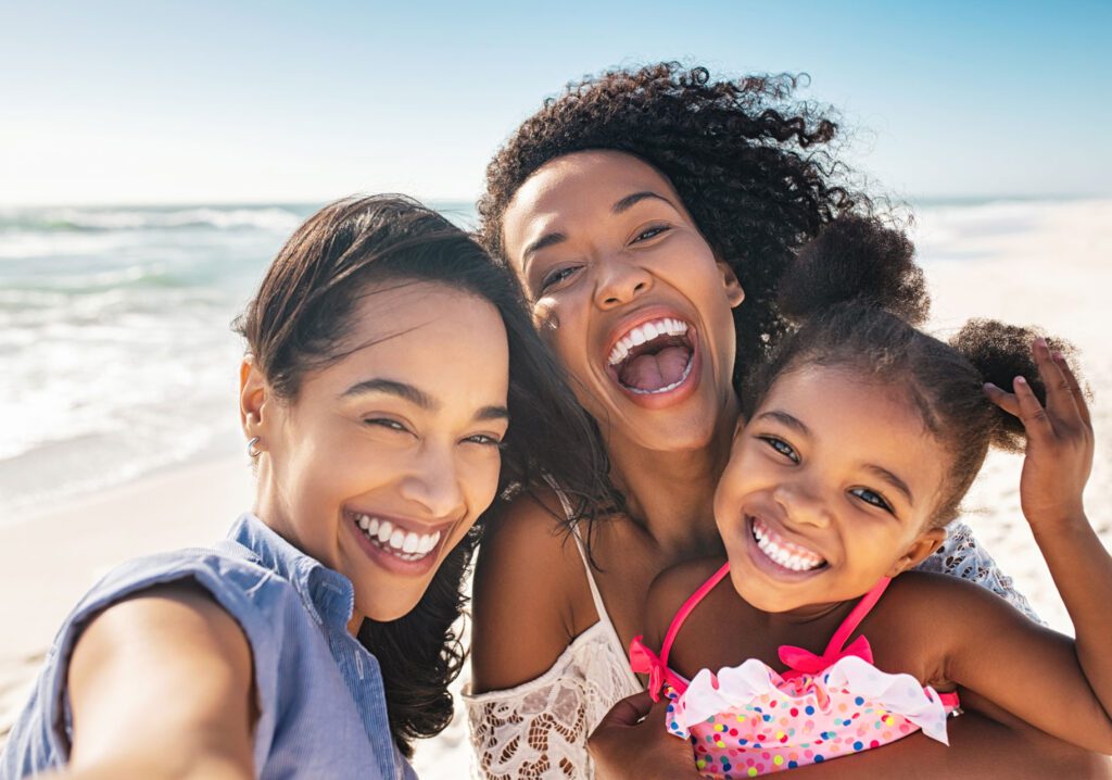 happy parents and child selfie at the beach