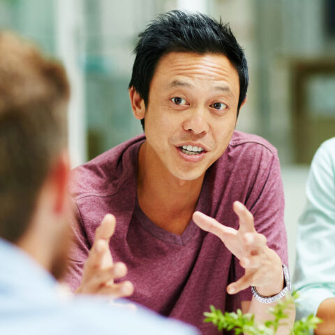 Shot of a group of people talking together around a table in an office