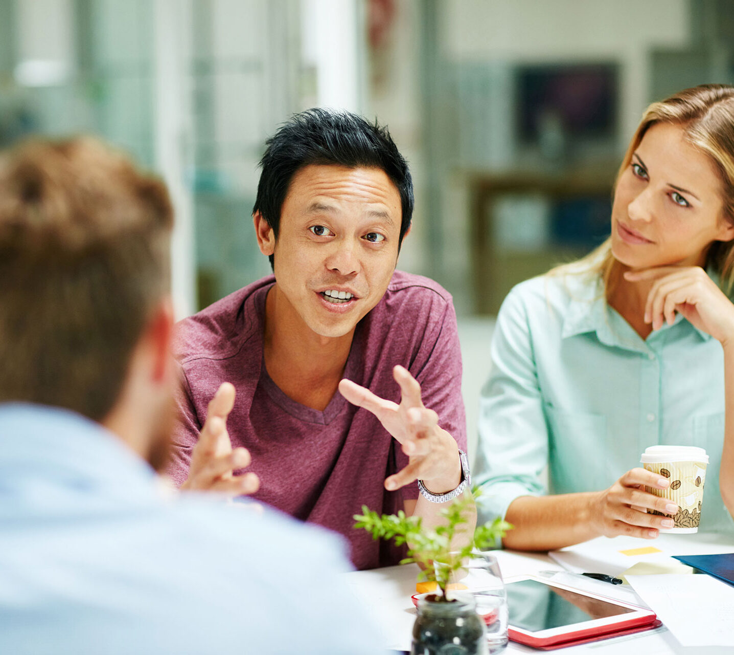 Shot of a group of people talking together around a table in an office