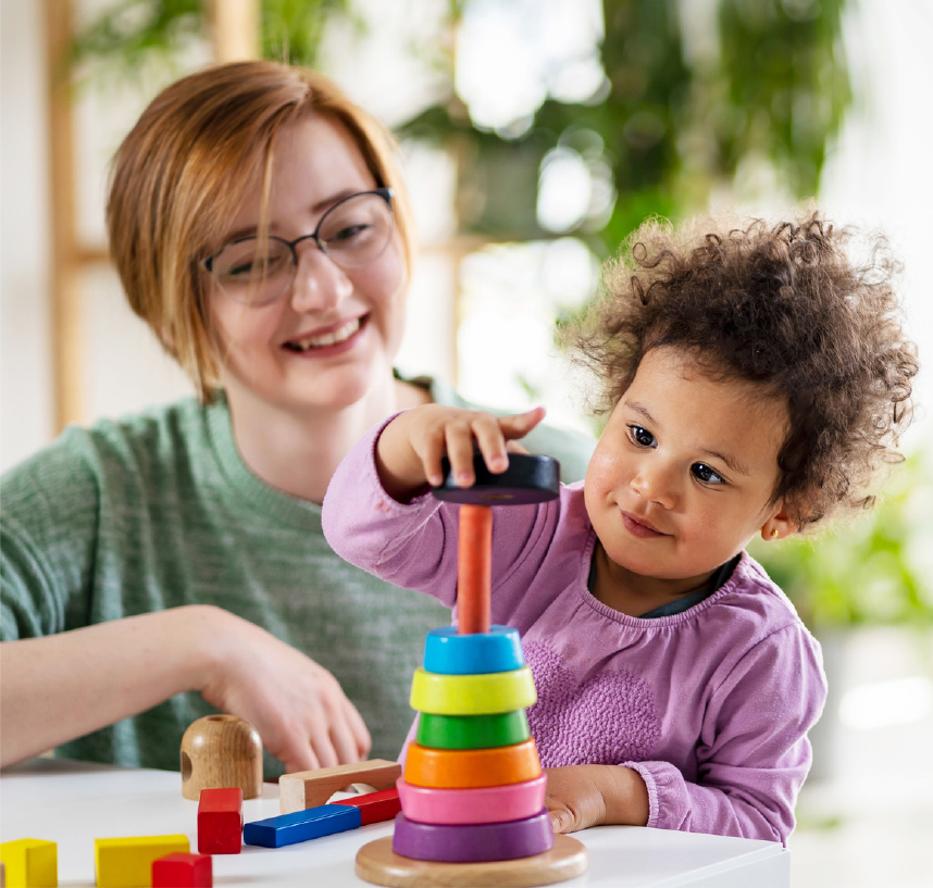 adult watches child play with toys