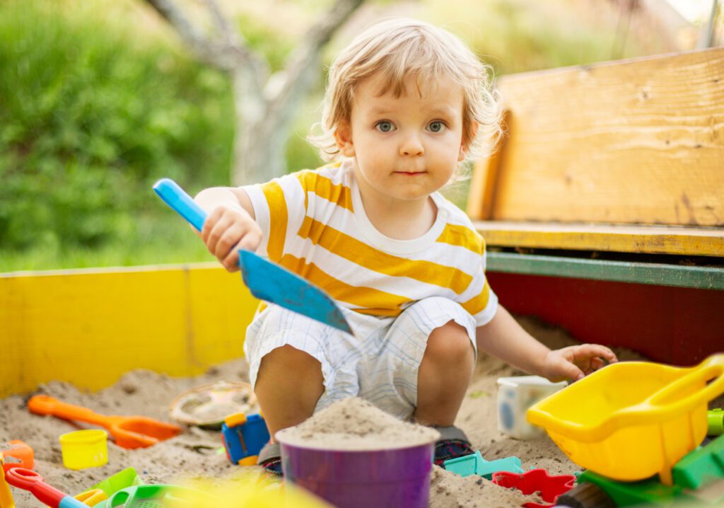 child plays in sandbox