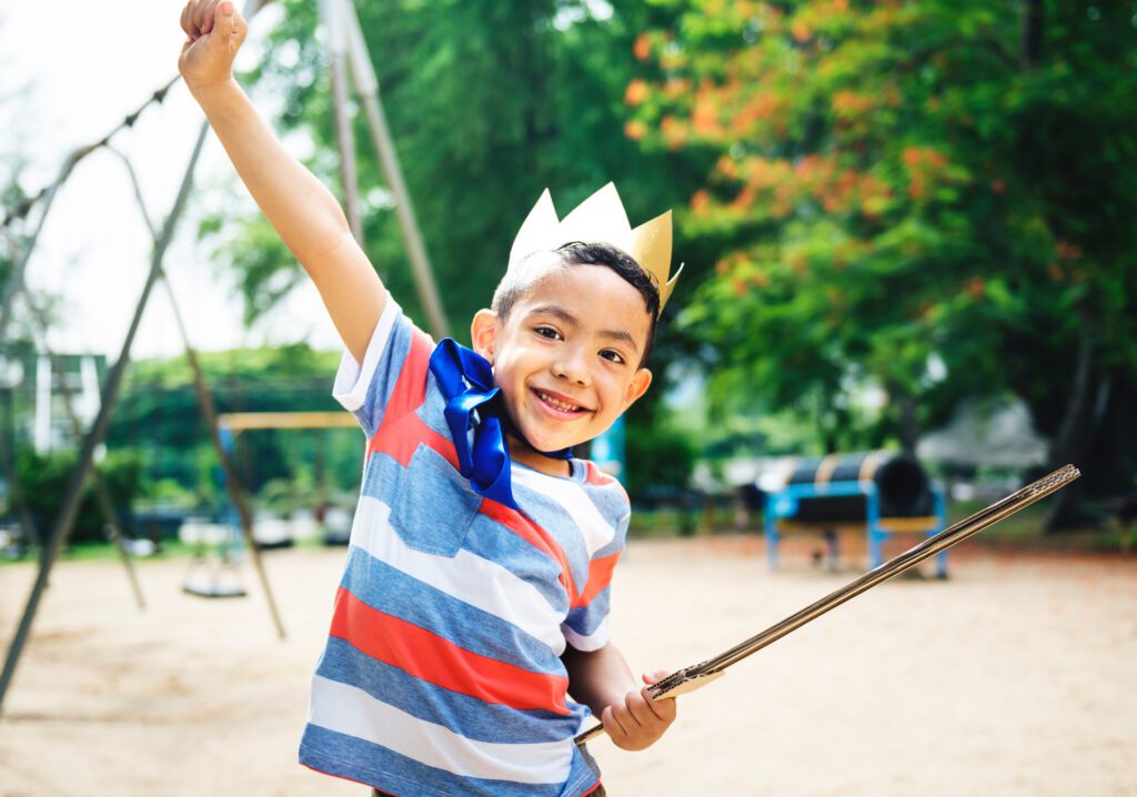 child role-plays with crown and sword