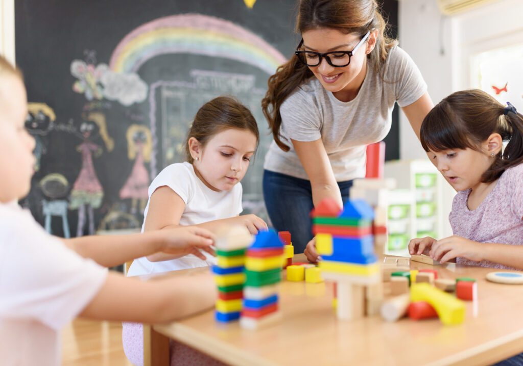 teacher and children playing with blocks