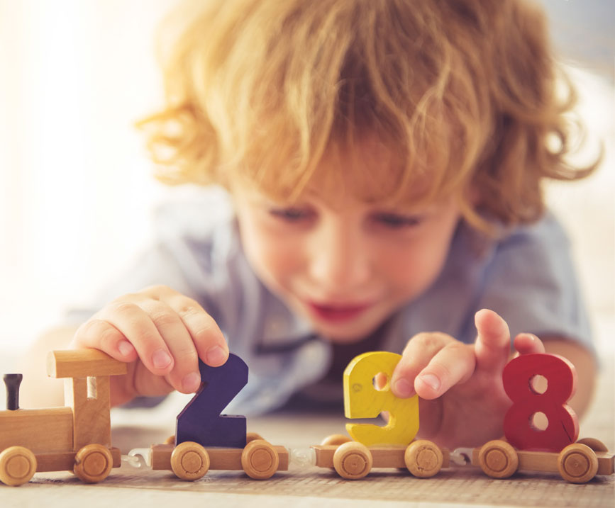 child plays with wooden train number toys